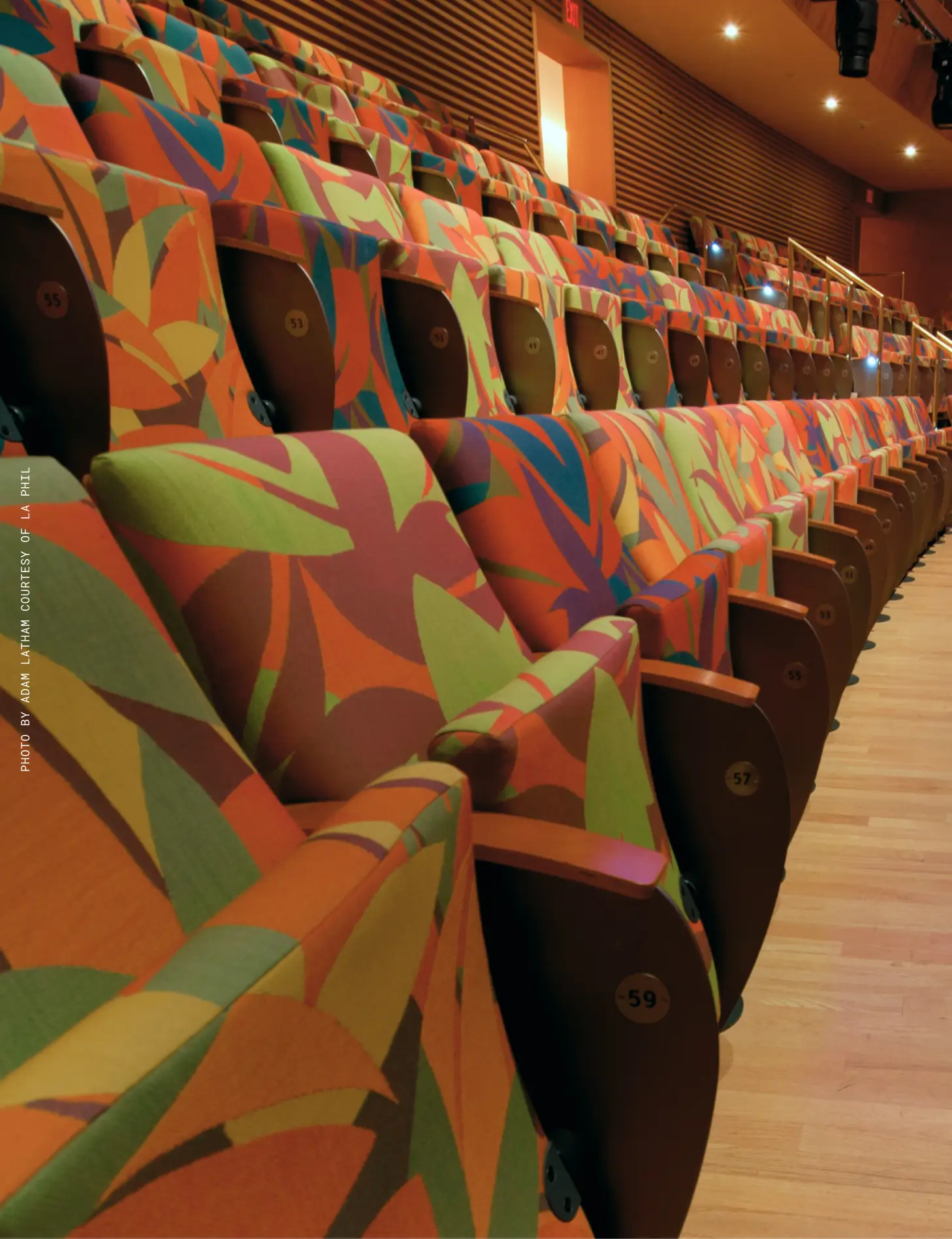 A view of the audience seating inside Walt Disney Concert Hall. Each seat has a colorful pattern in oranges, reds, greens, and purples that suggests an abstract floral motif.