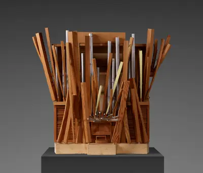A scale model of an organ constructed in two types of wood with pipes positioned at dynamic angles. Some pipes are painted to suggest the appearance of metal. Musical notes are annotated atop the pipes.