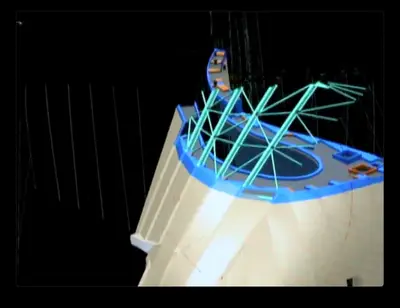 A screen capture of a CATIA digital model of Walt Disney Concert Hall. The digital model is rendered in blue and beige on a black background, showing elements of the structure and cladding of the building.