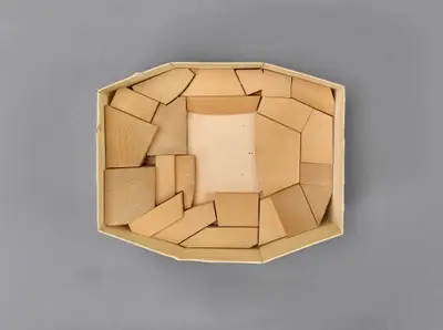 A model of the Walt Disney Concert Hall interior constructed in simple materials schematically illustrates the eight-sided, symmetrical shape of the room. Wood blocks suggest the placement of seating balconies within it.