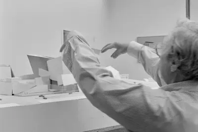 Frank Gehry gestures toward a model of Walt Disney Concert Hall constructed in paper