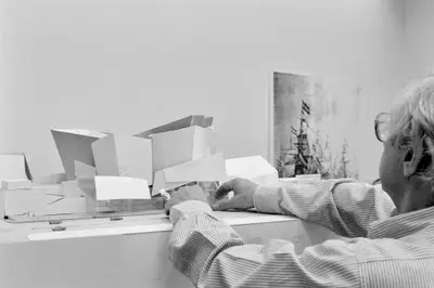 Frank Gehry adjusts a model of Walt Disney Concert Hall constructed in paper