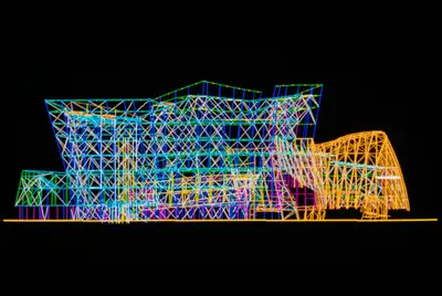 A screen capture of a CATIA digital model of Walt Disney Concert Hall. The digital model is rendered in a multicolor-on-black wireframe style that shows internal and external portions of the building.