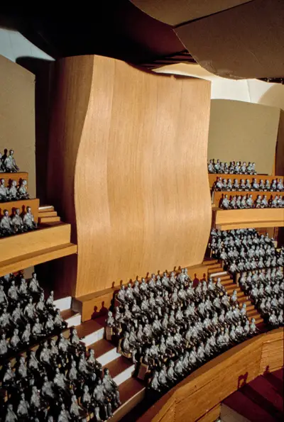 A scale model of an organ encased in an undulating, wood box sits within a scale model of the Walt Disney Concert Hall interior.