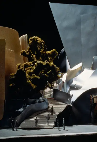 A close-up of an exterior model of Walt Disney Concert Hall includes figurines and model trees.