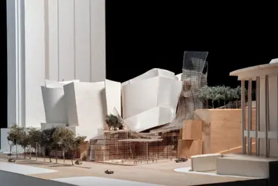 A pedestrian's-eye view of a model of Walt Disney Concert Hall constructed in wood, acrylic, and paper suggests the dynamic appearance of the building within its urban context. Scale cars and trees afford realism.