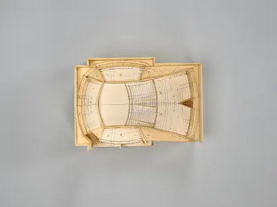 A model of the Walt Disney Concert Hall interior constructed in simple materials schematically illustrates the dimensions of the room and the arrangement of seats and the stage within it. Printed lines suggest the placement of aisles, stairs, and other details.