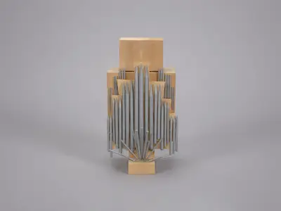 A scale model of an organ constructed in wood with pipes positioned above and hanging down. Pipes are painted to suggest the appearance of metal.